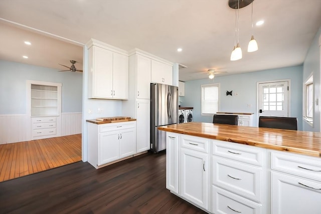 kitchen featuring dark wood finished floors, butcher block countertops, freestanding refrigerator, and washing machine and clothes dryer