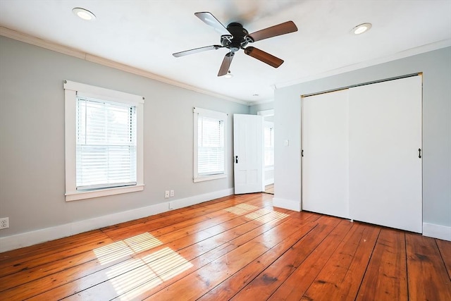 unfurnished bedroom with crown molding, hardwood / wood-style flooring, and baseboards