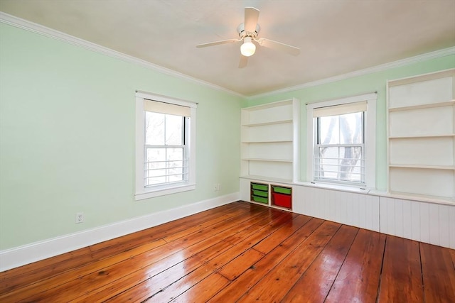 empty room with plenty of natural light, wood-type flooring, and ornamental molding