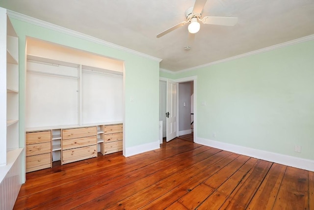 unfurnished bedroom with a closet, crown molding, baseboards, and hardwood / wood-style flooring