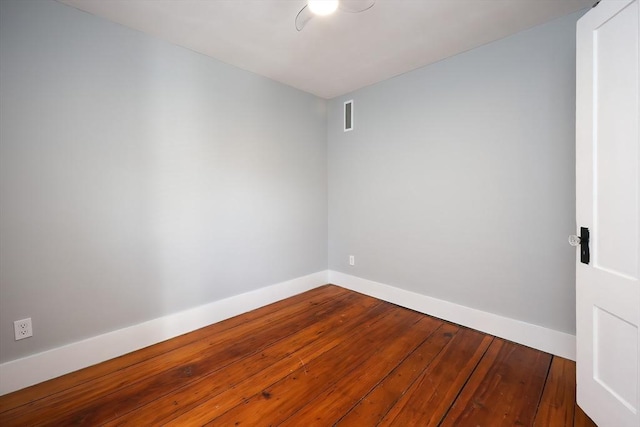 empty room featuring visible vents, baseboards, and hardwood / wood-style floors