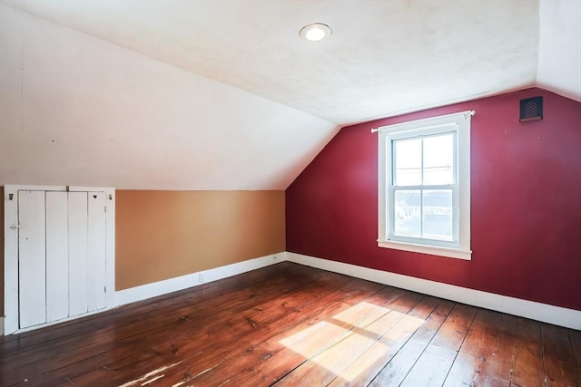 additional living space featuring hardwood / wood-style floors, lofted ceiling, and baseboards