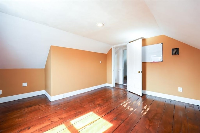 additional living space featuring baseboards, lofted ceiling, and hardwood / wood-style flooring