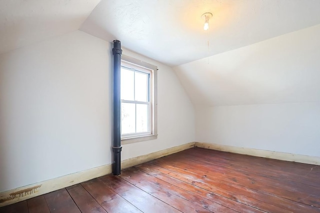 additional living space with hardwood / wood-style floors and lofted ceiling