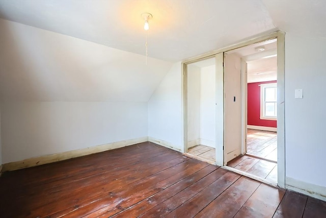 additional living space featuring baseboards, lofted ceiling, and hardwood / wood-style floors