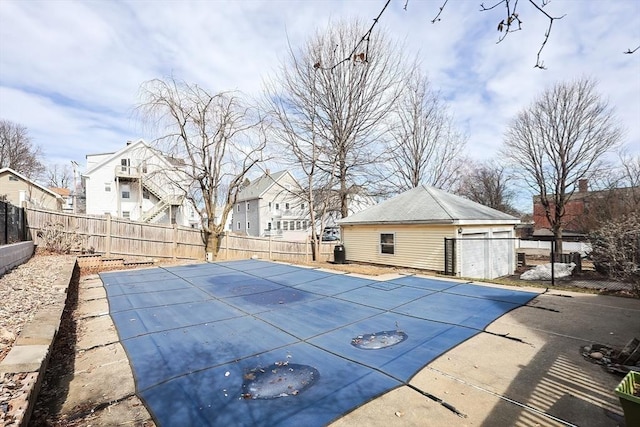 view of swimming pool featuring an outbuilding, a patio, a fenced backyard, a residential view, and a fenced in pool