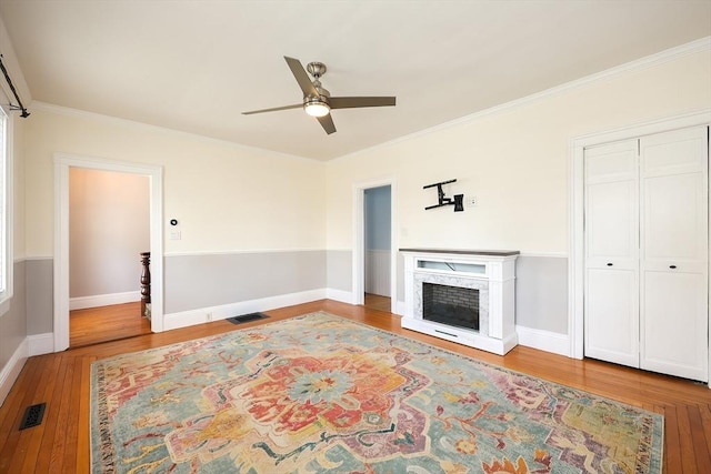 living room featuring wood finished floors, visible vents, and a high end fireplace