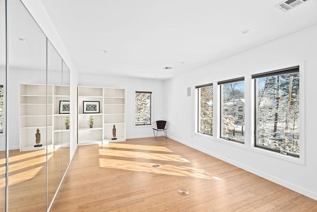 exercise room with light hardwood / wood-style floors