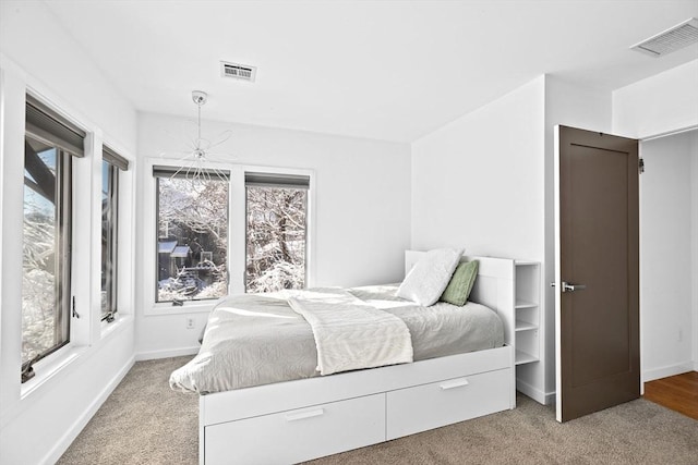 carpeted bedroom featuring a notable chandelier