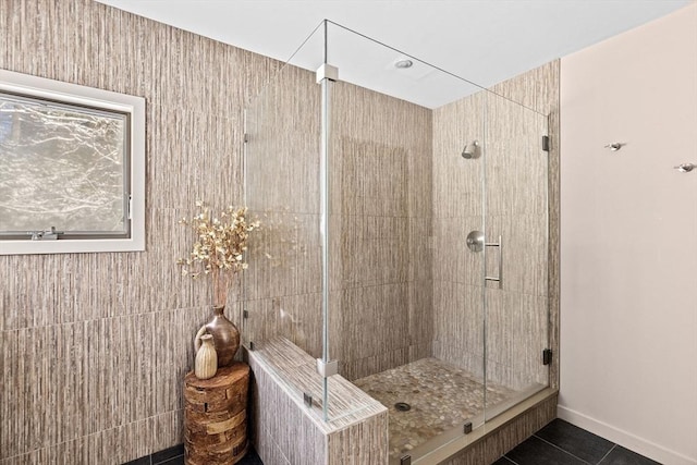 bathroom with a shower with door and tile patterned flooring