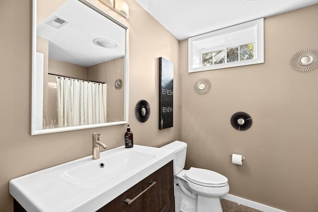 bathroom featuring toilet, vanity, and a shower with shower curtain