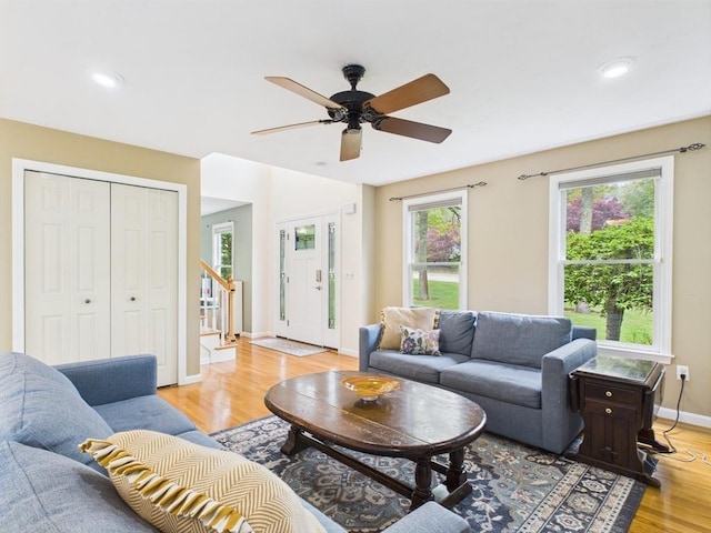 living room with light wood finished floors, stairs, a ceiling fan, baseboards, and recessed lighting