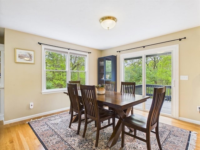 dining area featuring light wood-style flooring and baseboards