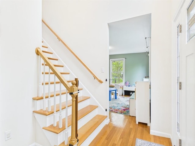 staircase with wood finished floors and baseboards