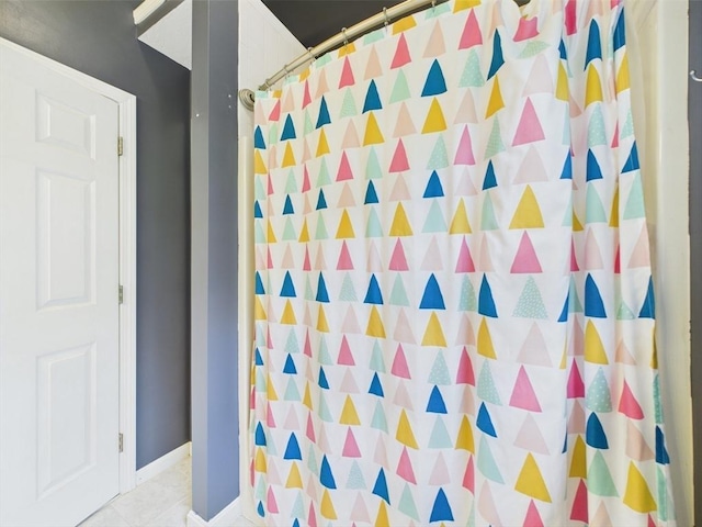 bathroom with a shower with curtain and tile patterned flooring