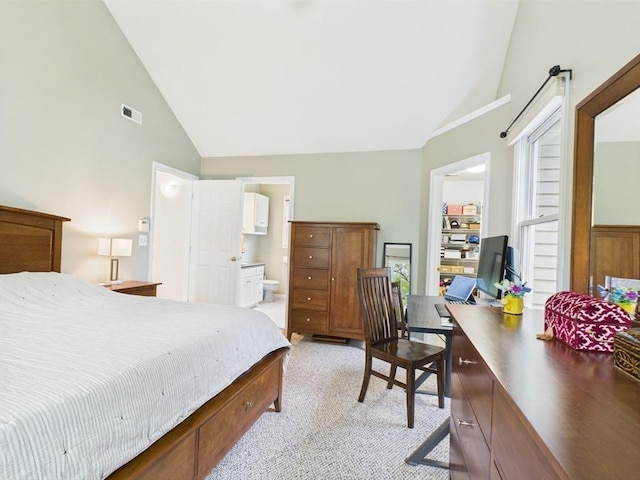 bedroom with high vaulted ceiling, an office area, light colored carpet, and connected bathroom