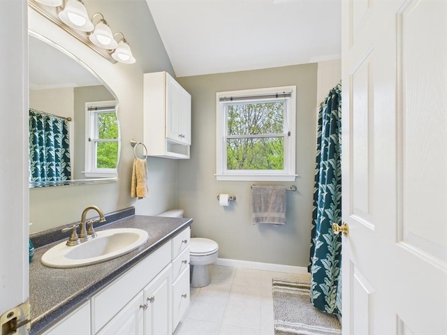 full bathroom with healthy amount of natural light, vanity, toilet, tile patterned flooring, and vaulted ceiling