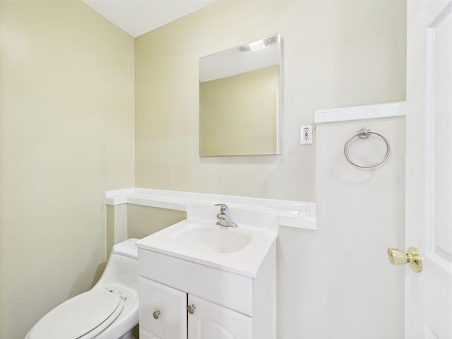 half bathroom featuring vanity and toilet