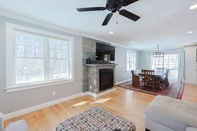 living room with a fireplace, recessed lighting, light wood-style flooring, ornamental molding, and baseboards