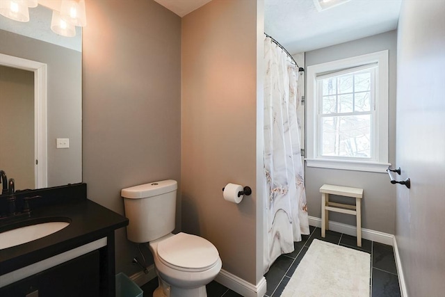 bathroom featuring baseboards, vanity, toilet, and tile patterned floors