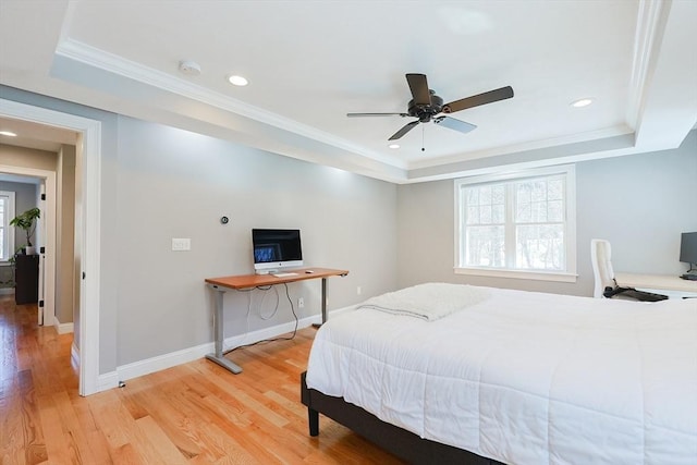 bedroom with recessed lighting, baseboards, light wood-type flooring, a raised ceiling, and crown molding