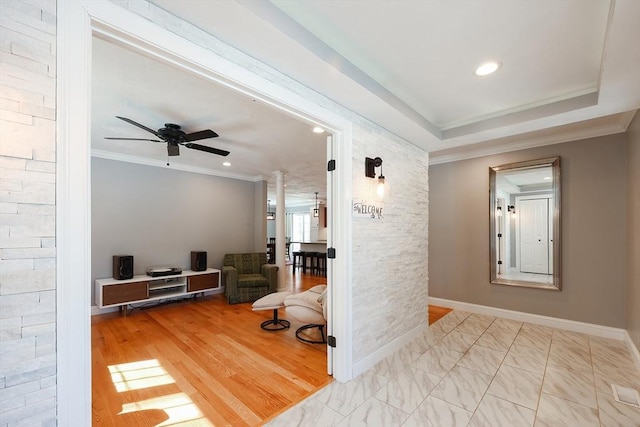 corridor featuring baseboards, a raised ceiling, crown molding, and recessed lighting