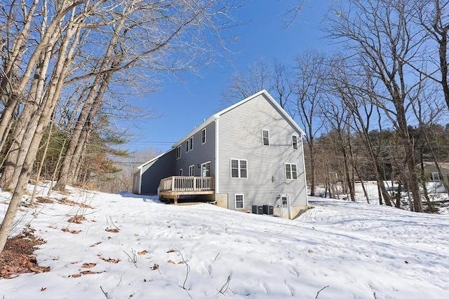 view of snowy exterior featuring a deck and central AC unit