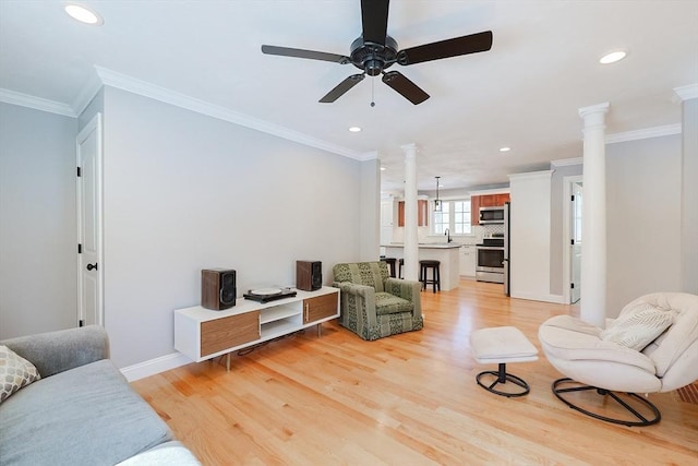 living room with ornamental molding, light wood-type flooring, and decorative columns