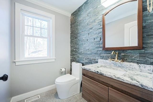 half bath with baseboards, visible vents, toilet, ornamental molding, and vanity