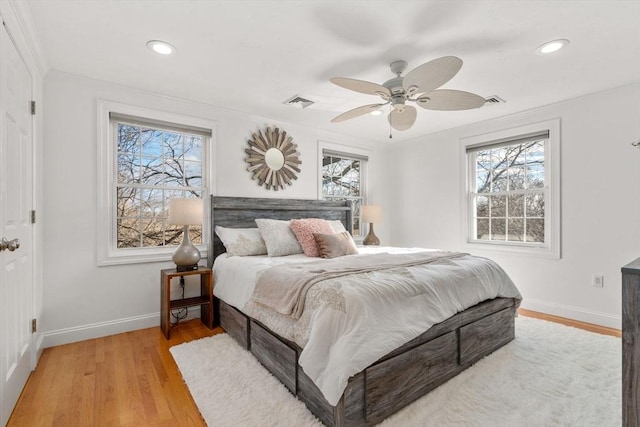 bedroom featuring crown molding, light hardwood / wood-style flooring, and ceiling fan