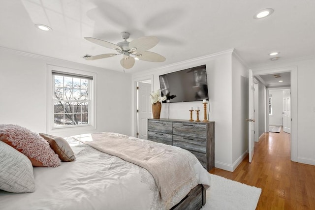 bedroom featuring hardwood / wood-style floors, crown molding, and ceiling fan