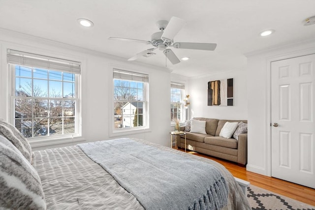 bedroom featuring crown molding, ceiling fan, and light hardwood / wood-style floors