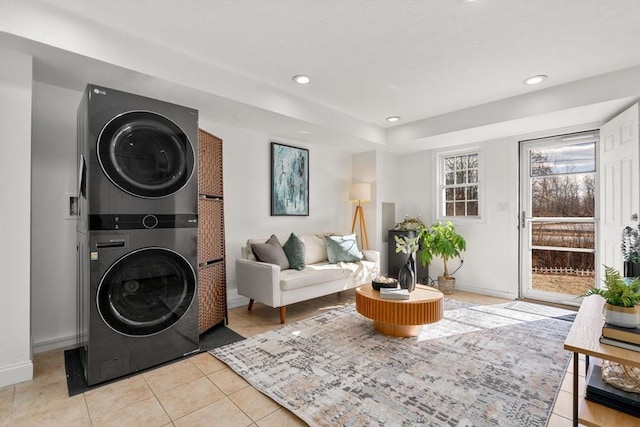 laundry room featuring light tile patterned flooring and stacked washer / drying machine