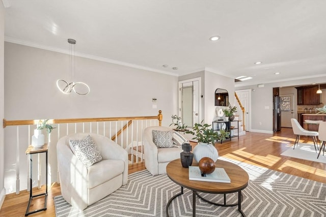 living room featuring ornamental molding, light hardwood / wood-style floors, and a chandelier