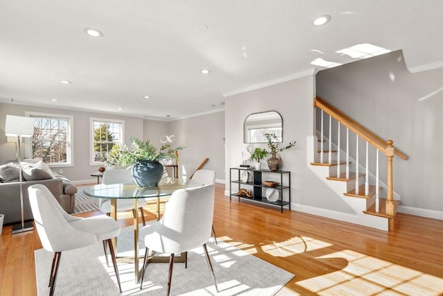 dining space featuring crown molding and light hardwood / wood-style flooring