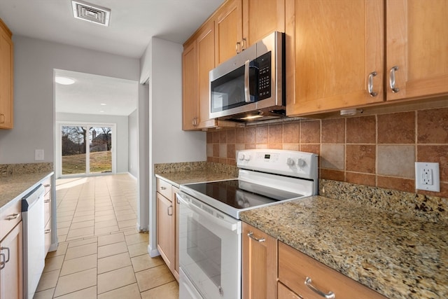 kitchen featuring decorative backsplash, light stone counters, white appliances, and light tile patterned floors