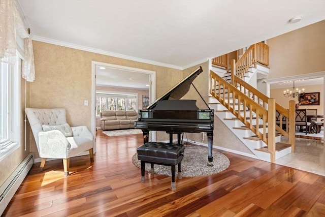 living area featuring baseboard heating, stairs, wood finished floors, a chandelier, and baseboards