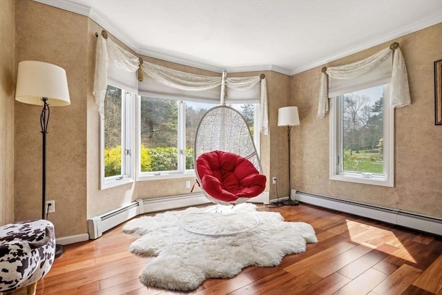 sitting room with ornamental molding, wood-type flooring, healthy amount of natural light, and a baseboard radiator