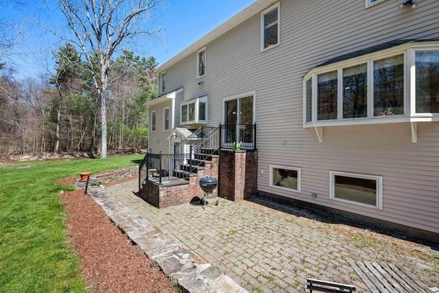 view of property exterior featuring a patio area and a lawn