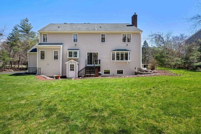 rear view of property with a chimney and a lawn