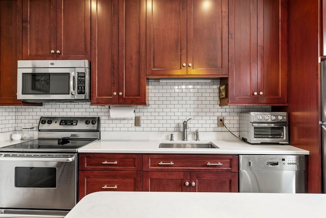 kitchen with appliances with stainless steel finishes, sink, and tasteful backsplash