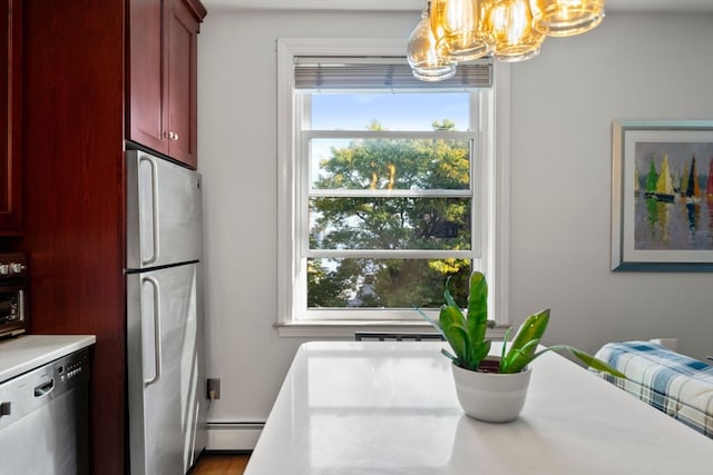 dining space with a baseboard heating unit, a chandelier, wood-type flooring, and a healthy amount of sunlight