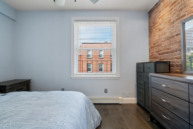 bedroom with multiple windows, dark hardwood / wood-style flooring, a baseboard heating unit, and brick wall