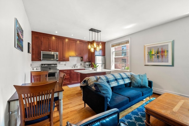 living room featuring sink, a chandelier, and light hardwood / wood-style floors