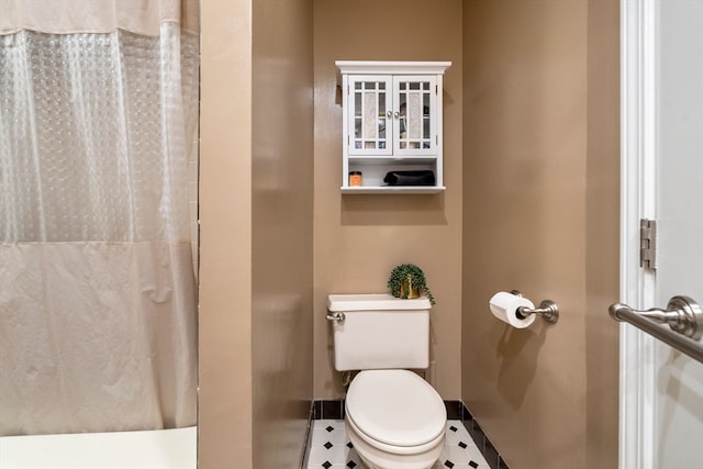 bathroom with tile patterned flooring, toilet, and curtained shower