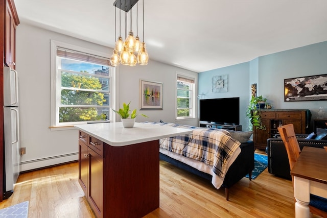 kitchen featuring light hardwood / wood-style flooring, a wealth of natural light, a center island, and hanging light fixtures