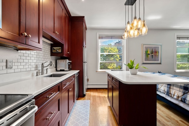 kitchen with light hardwood / wood-style flooring, plenty of natural light, hanging light fixtures, and sink