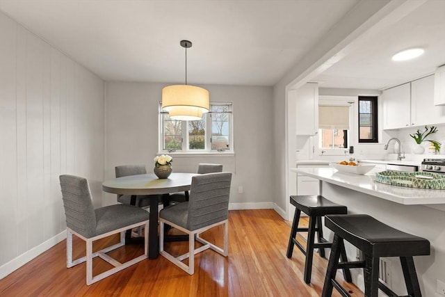 dining room with light wood-type flooring and sink