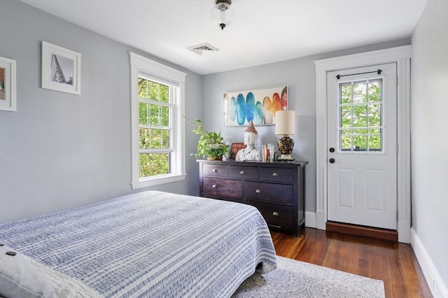 bedroom featuring dark wood finished floors, multiple windows, and baseboards
