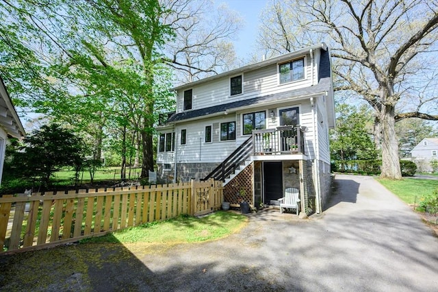 view of front of house with stairway and asphalt driveway